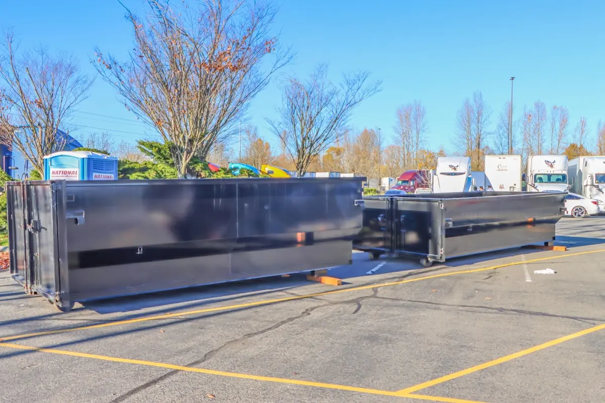 Professional dumpster rental service with roll-off container on residential driveway in Half Moon